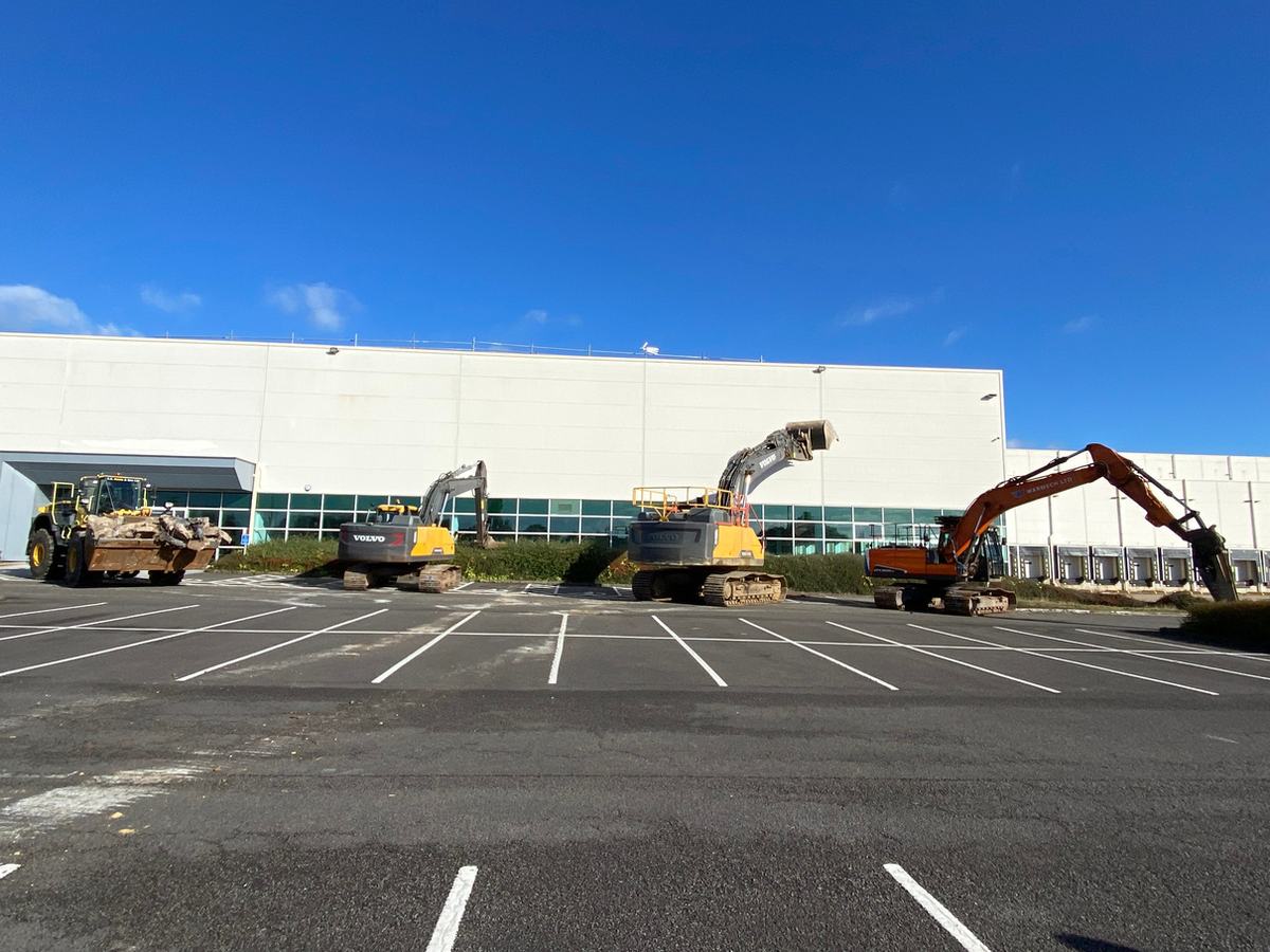 Surface Demolition excavators lined up at a warehouse site