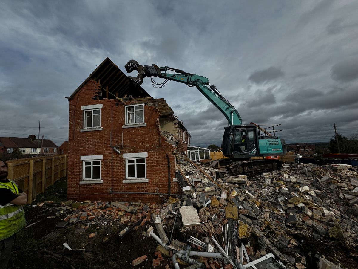Excavator taking down the gable end of Evelyn Court
